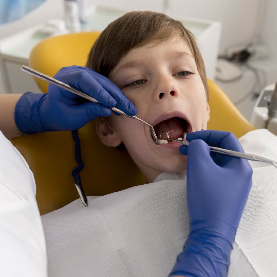 paura del dentista - bambino sulla poltrona del dentista durante una visita della bocca